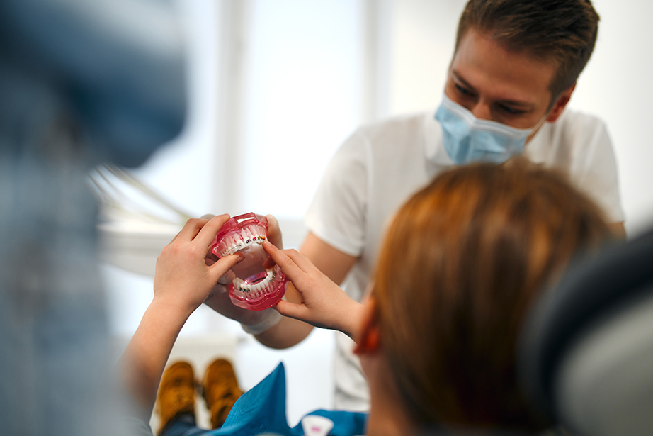 Man showing a child a brace for teeth