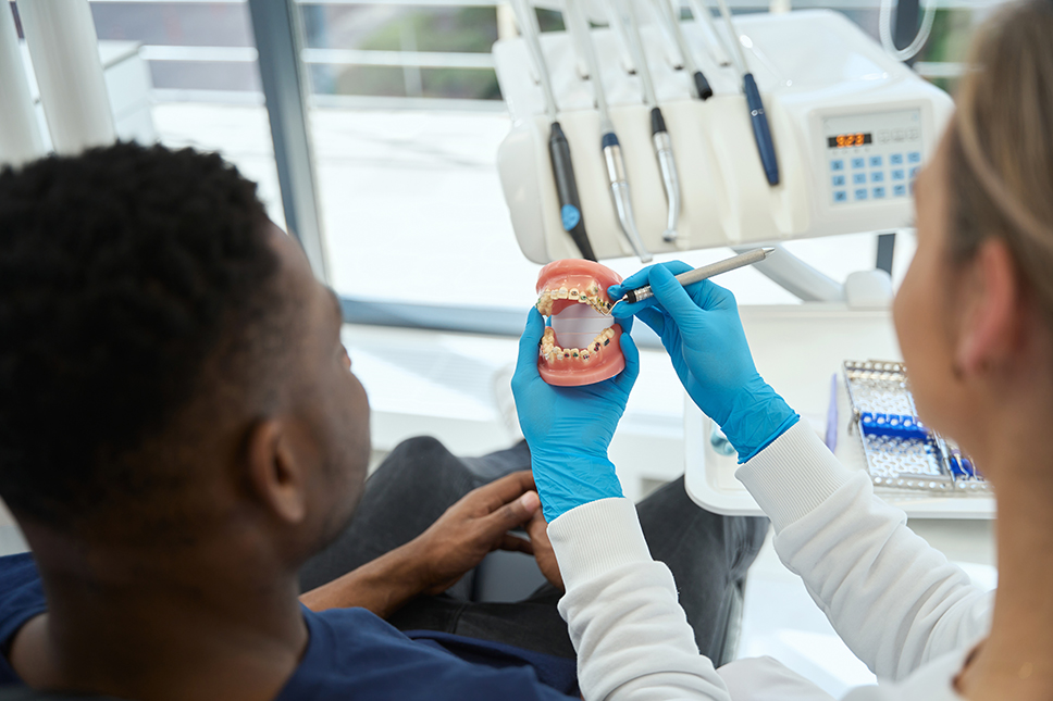 Dentist showing a patient the teeth model